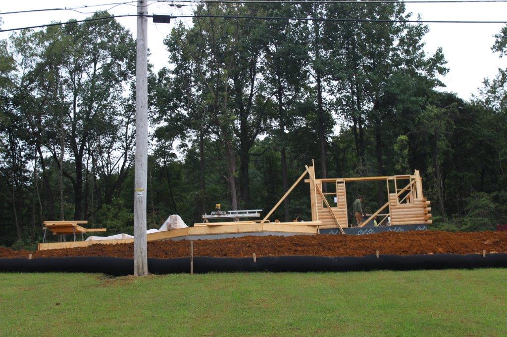 This pictures shows a few rows of logs with a door buck and window buck in place.