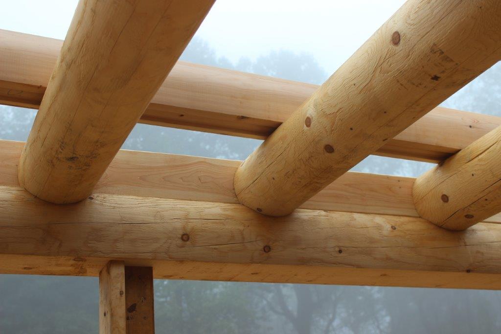 Here we see that some of the floor joists for the 2nd floor have been put in place.  Note craftsmanship where the ceiling joist meets the support.