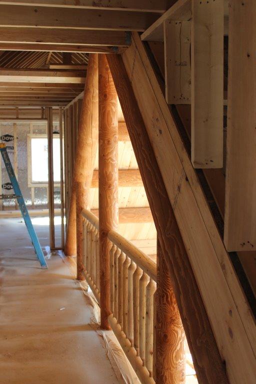 in the Lakeview the upstairs bedrooms are connected by a catwalk that overlooks the great room.  You can see the purlins to the right of the railing.